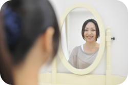 鏡を見る女性の画像